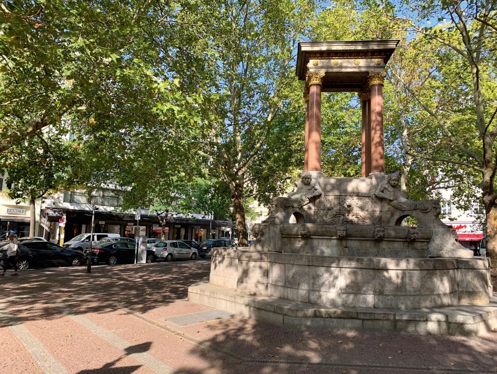 ein platz mit großem brunnen auf dem eine pagode mit 4 säulen steht