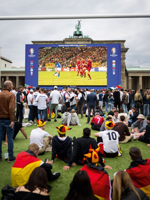 Fans gucken auf eine große Leinwand in der Fan-Zone