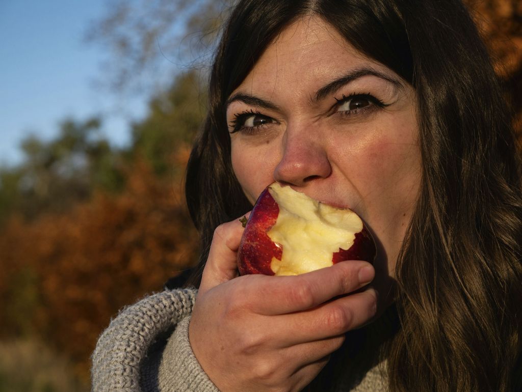 Eine Frau beisst in einen Apfel