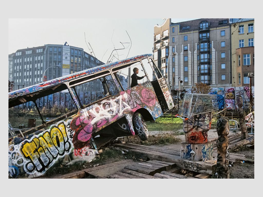 Kleiner junge in besprühtem kaputten Bus auf fdem ehemaligen Tacheles-Gelände